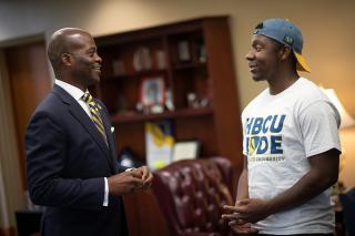 President Jenkins and student talking in the library